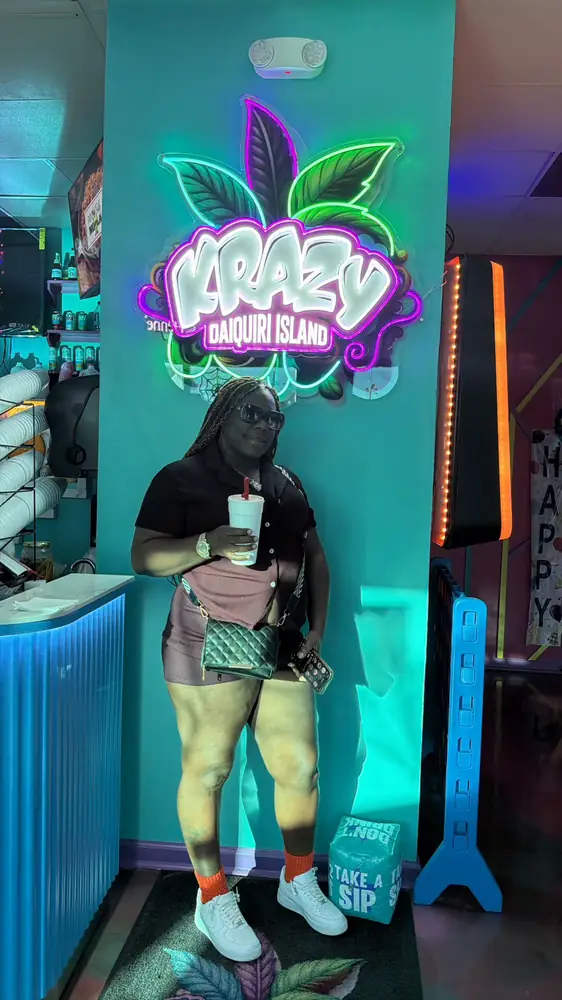 Guest with a novelty straw under the neon sign